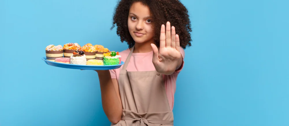 Pretty afro teenager looking serious, stern, displeased and angry showing open palm making stop gesture. humorous baker concept