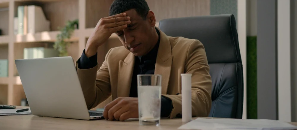 African American overworked businessman throw fizzy pill in glass of water apply drug supplement