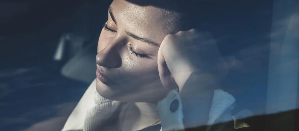 Close-up of young woman sleeping in car